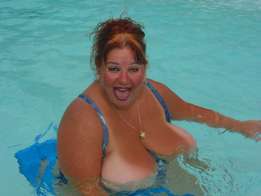 Пышногрудая толстуха плавает на надувном матрасе в бассейне. Фото - 1